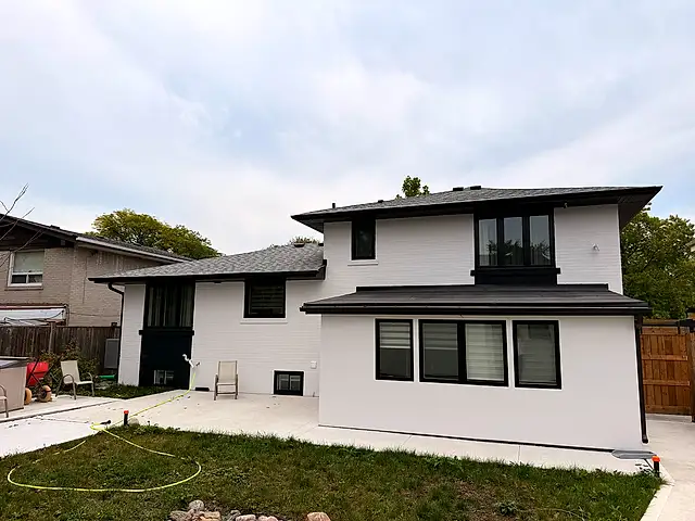 Rear of the house after painting, brick and stucco unified in white with black window frames