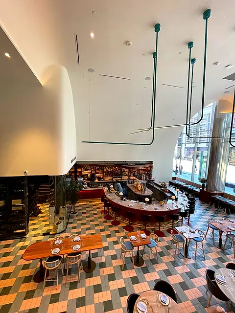 The finished restaurant with white walls and ceiling above a busy dining room